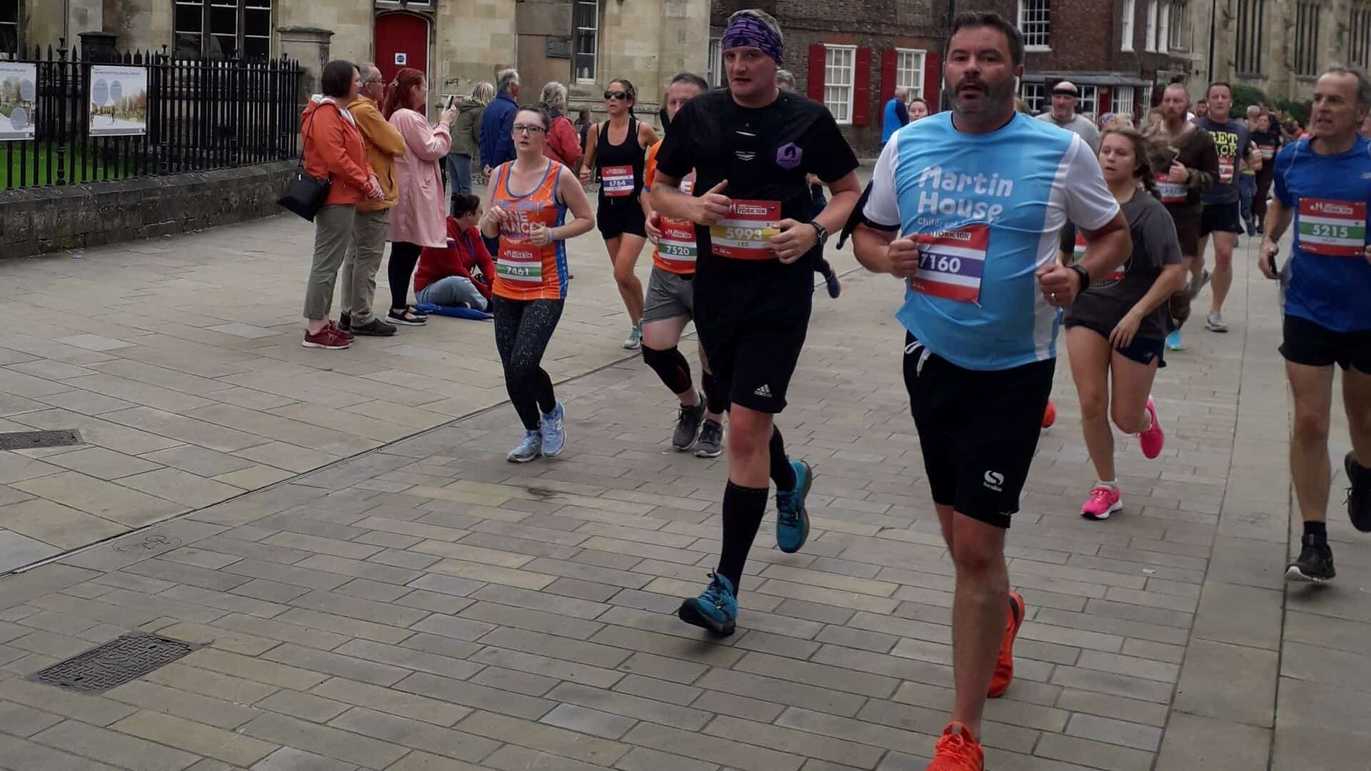 Man running wearing a blue Martin House t shirt