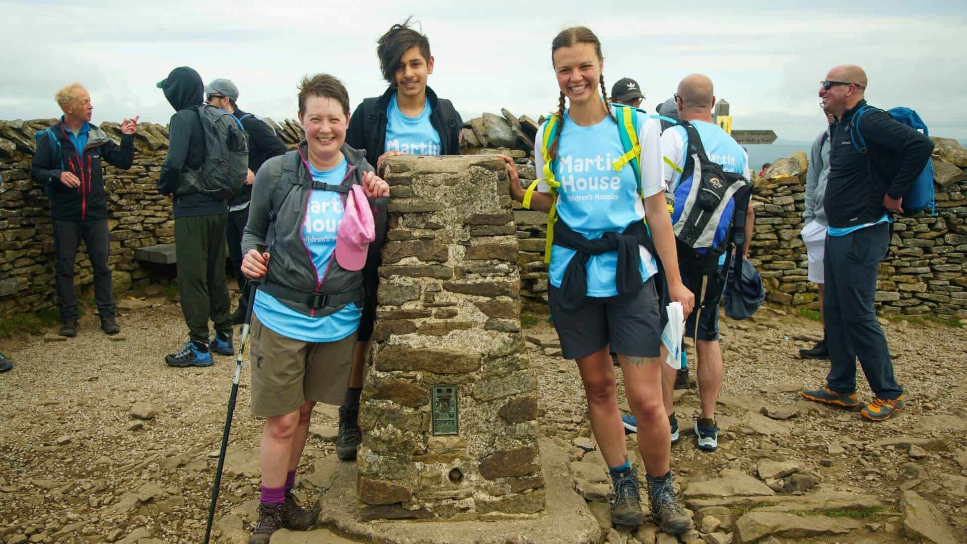 Three people at the top of one of the Yorkshire Three Peaks