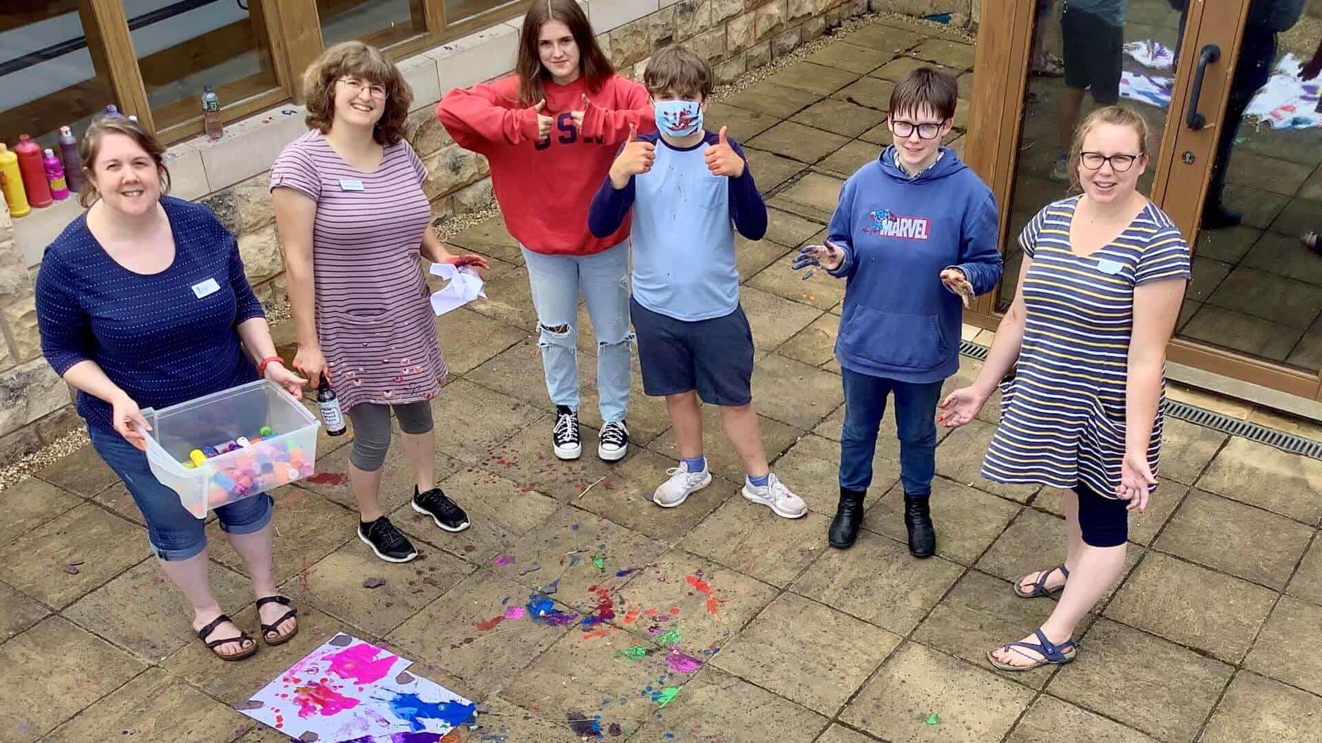 Three children doing art work outside with three adults.