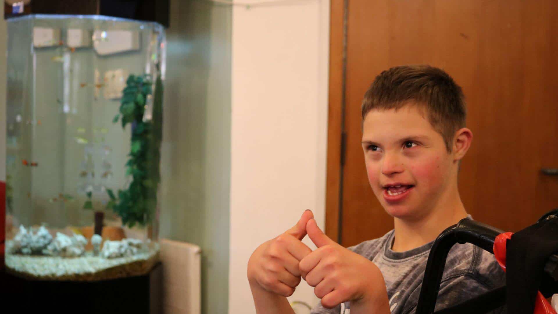 Boy smiling next to fish tank