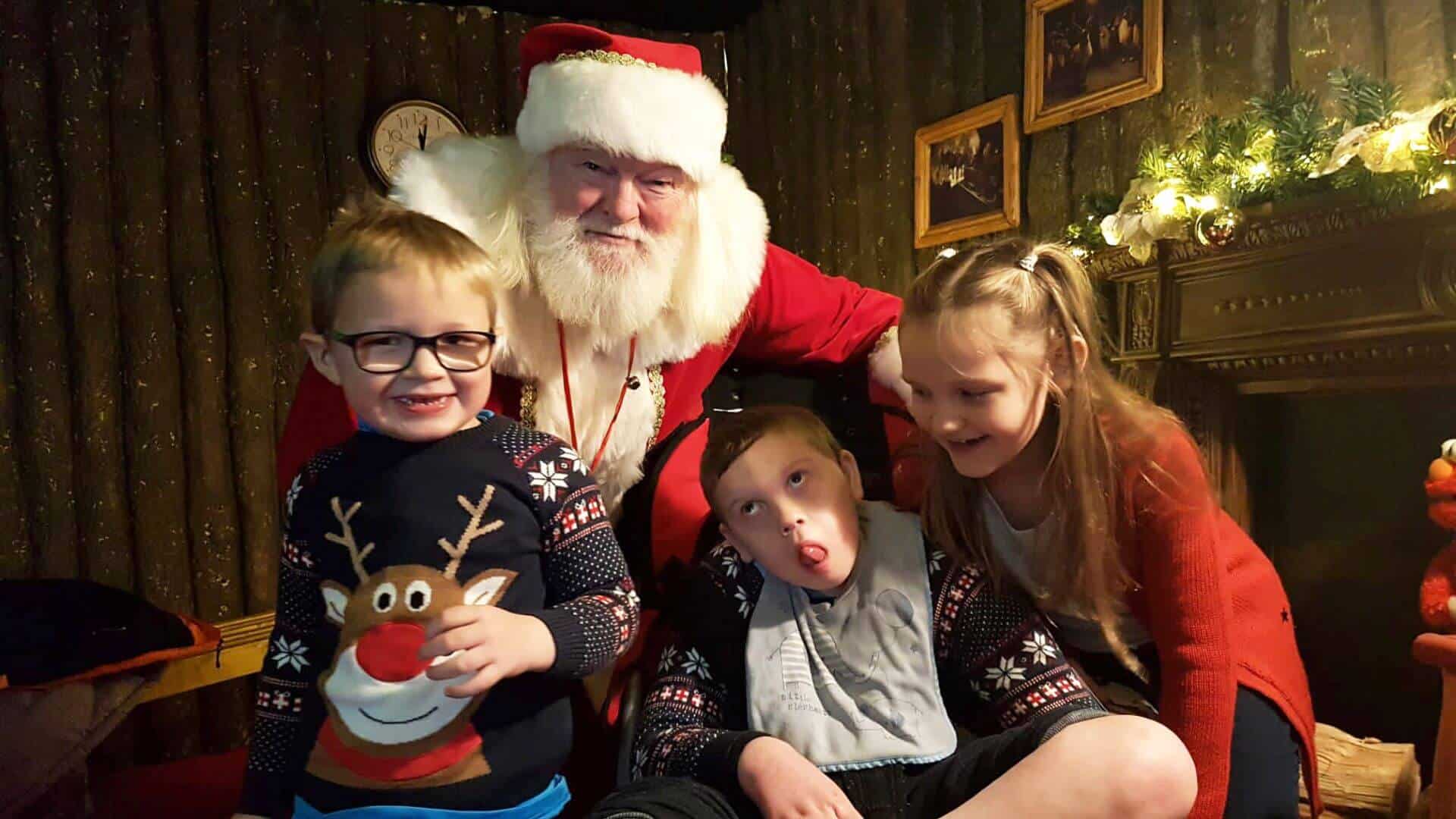 Three children sat with Father Christmas