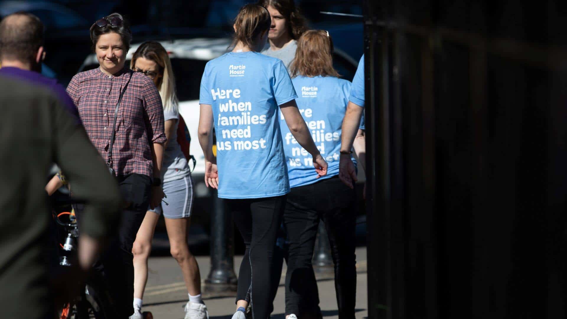 MH volunteers Back view of people walking wearing Martin House t-shirts.