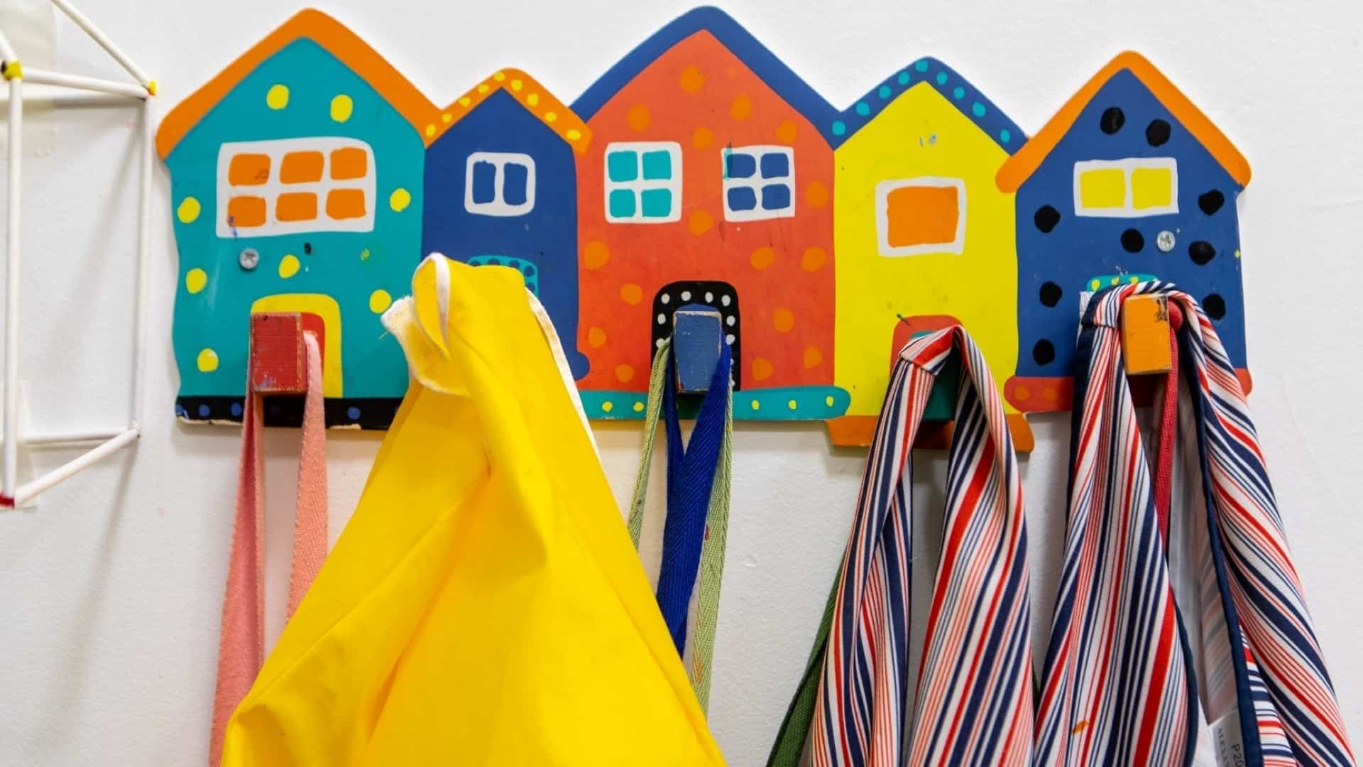 Coat pegs decorated with painted houses