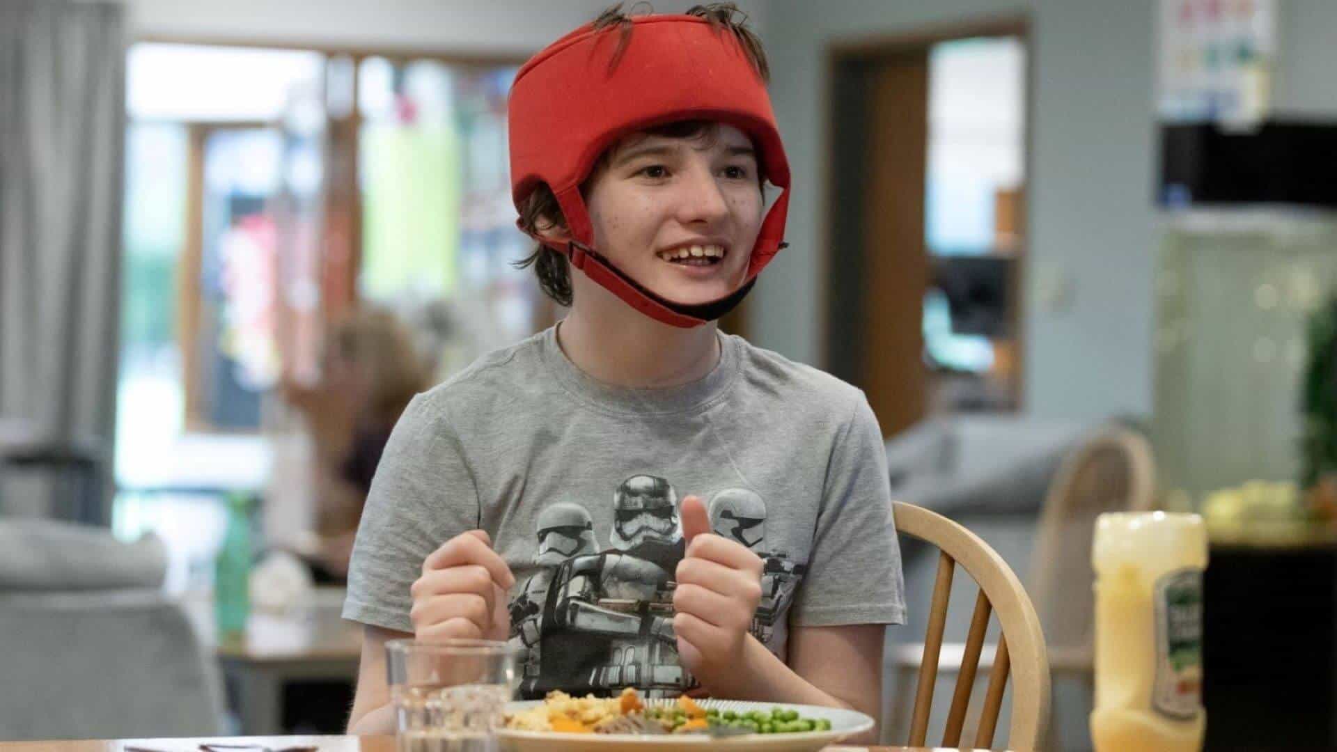 Young boy smiling eating dinner