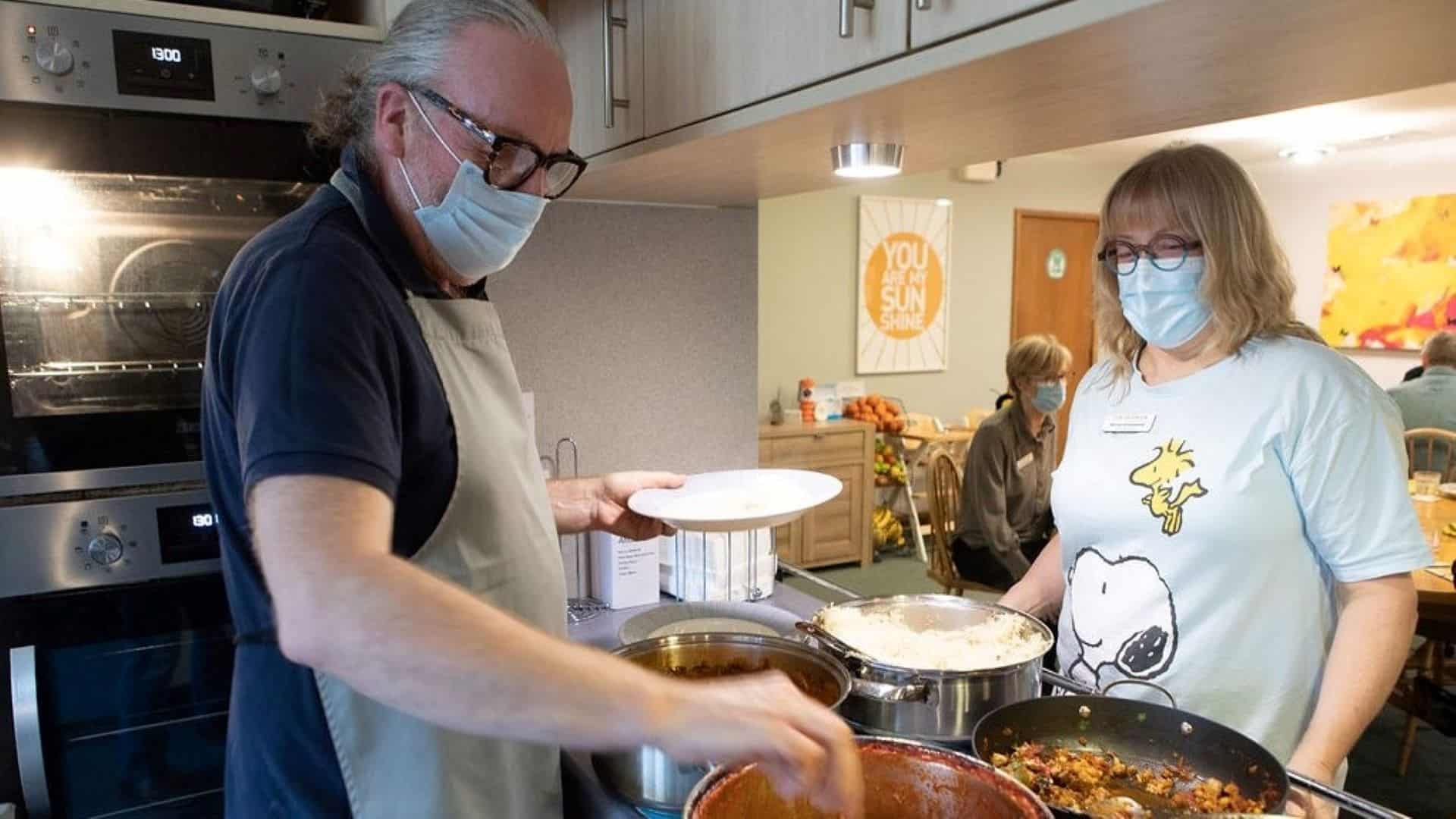 Chef cooking with woman watching.