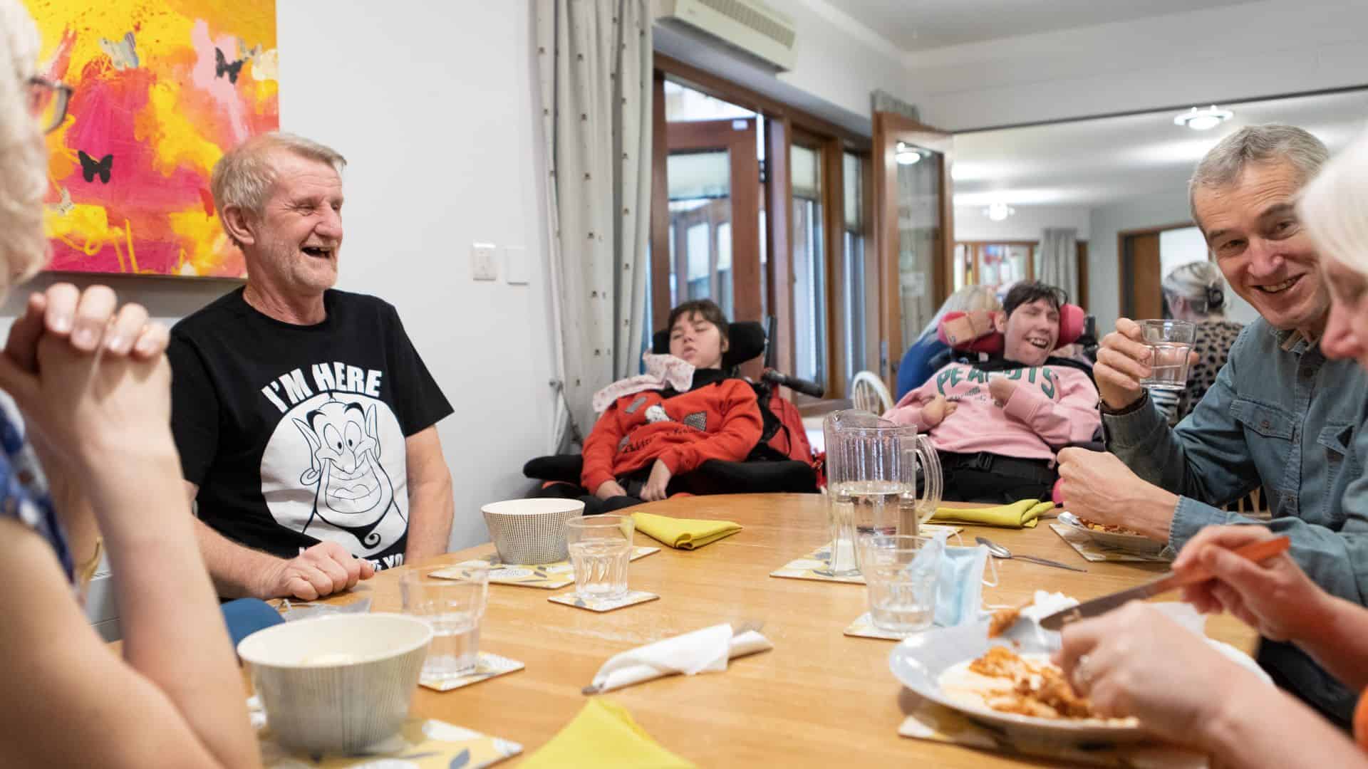 Family sat around table eating together.