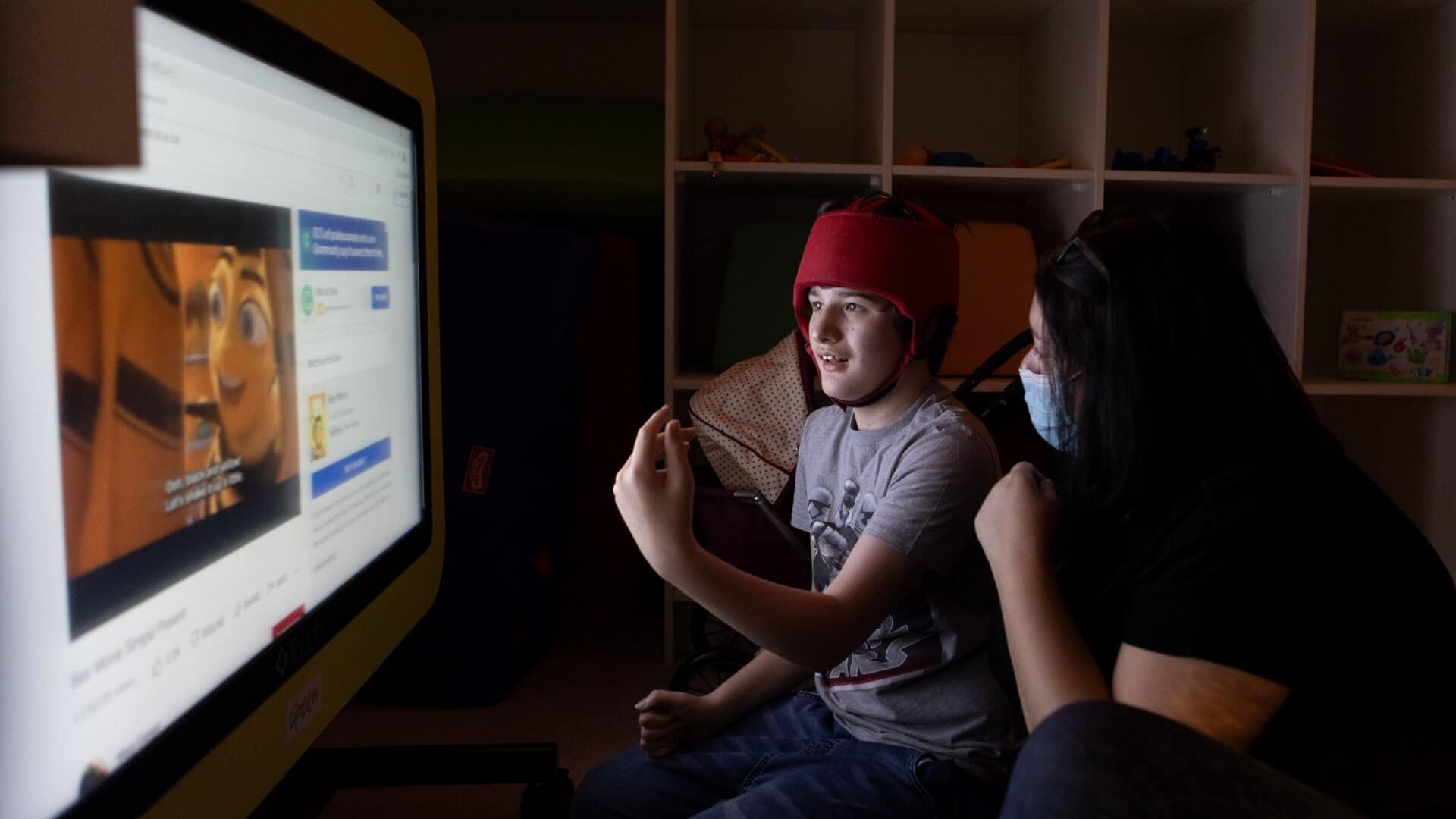 Woman and boy watching a film.