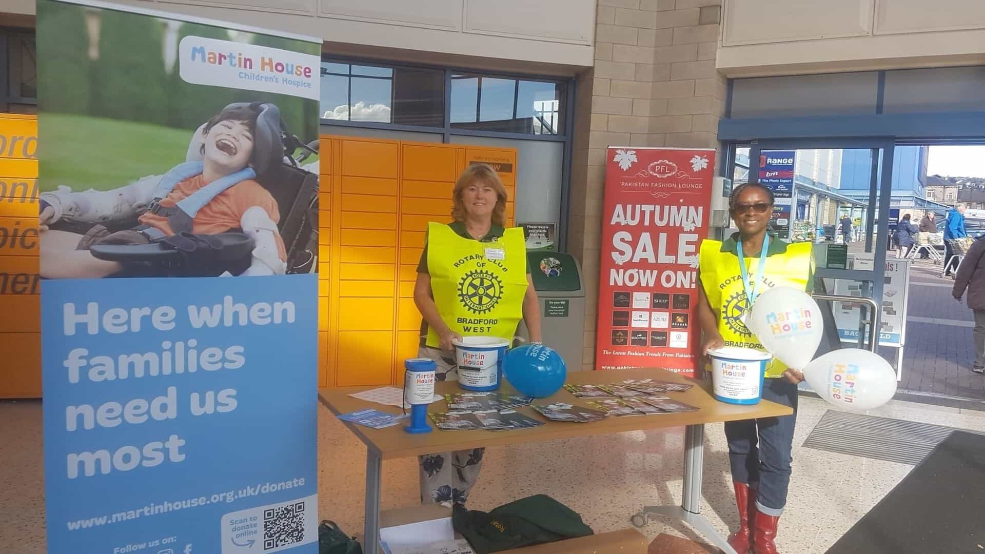 Two women stood behind table collecting money