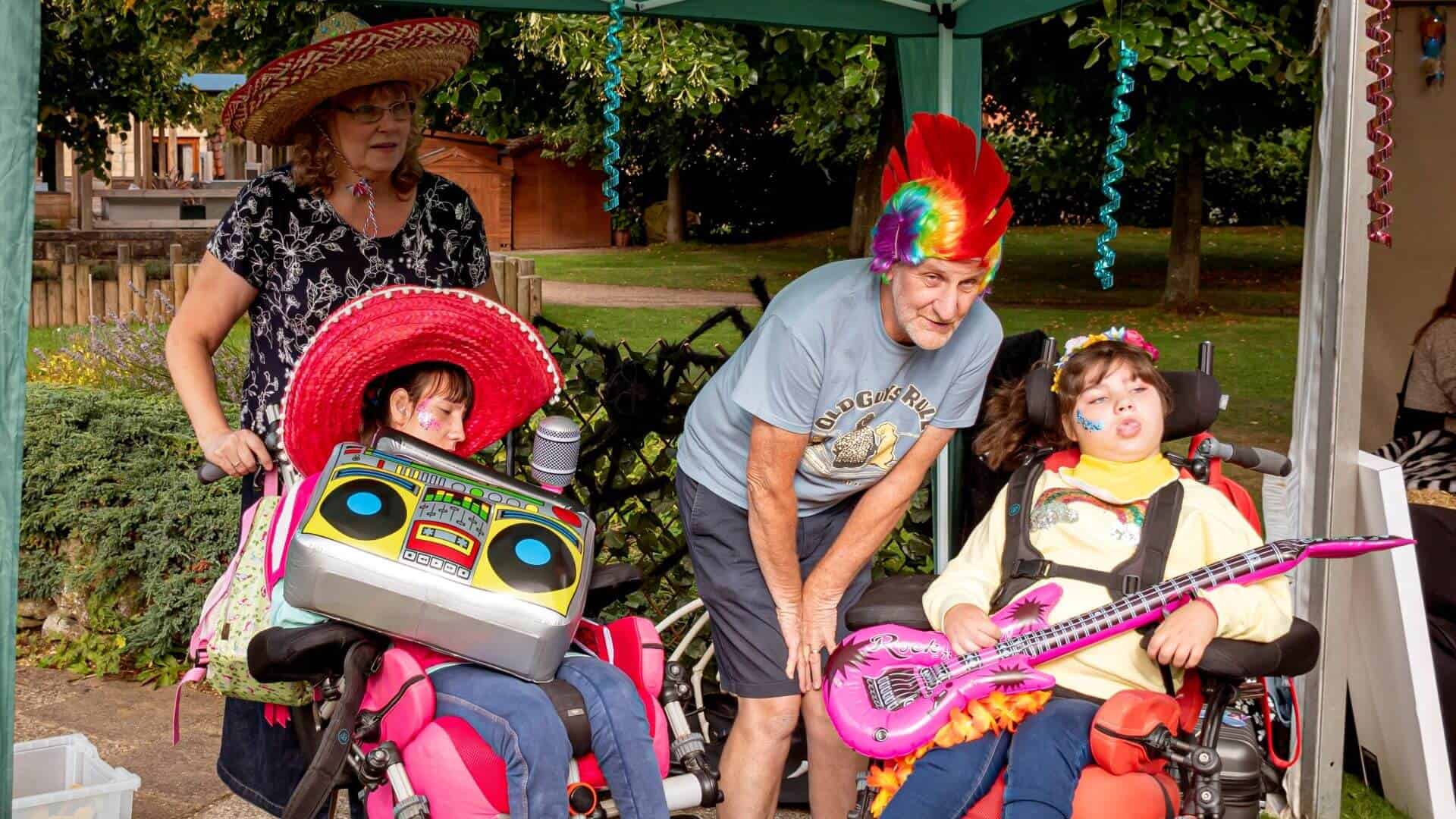 Mum, dad and two girls in fancy dress with musical toys.