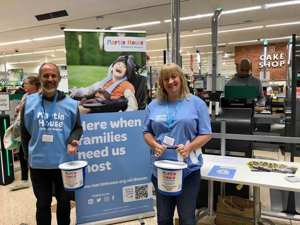 Man and woman collecting money with banner and bucket