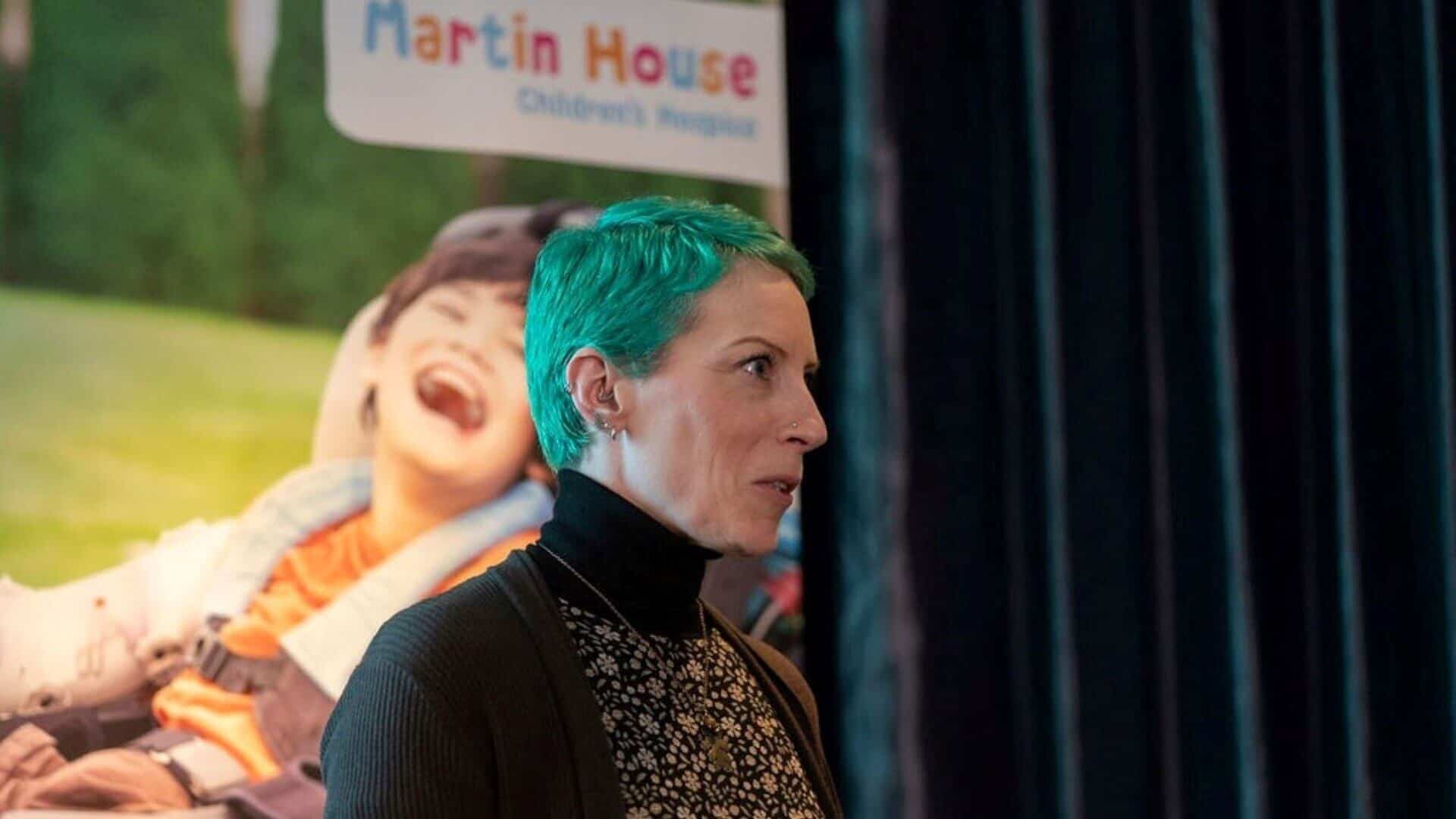 Woman presenting in front of Martin House banner.