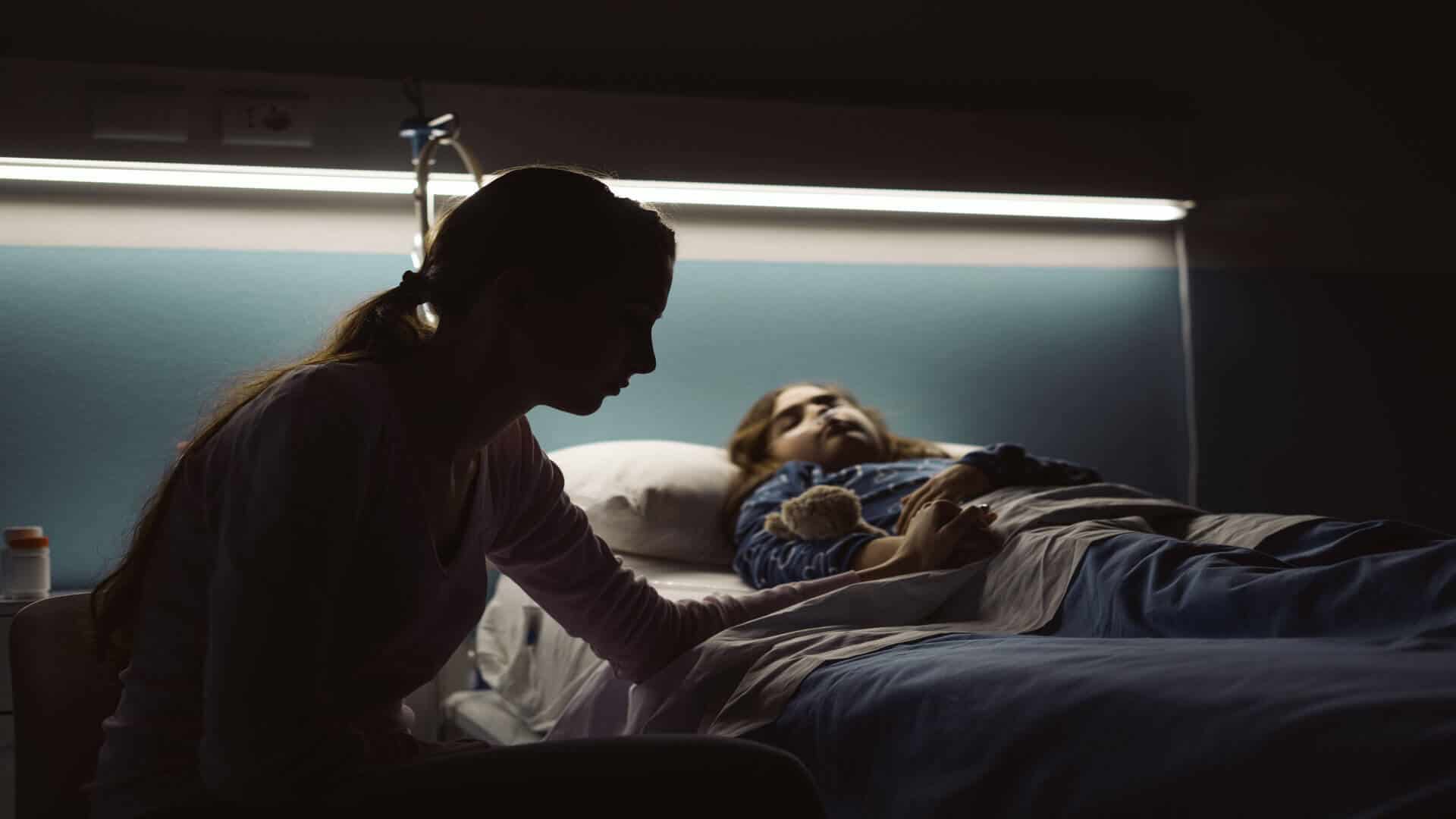 Woman sat by a child's bedside