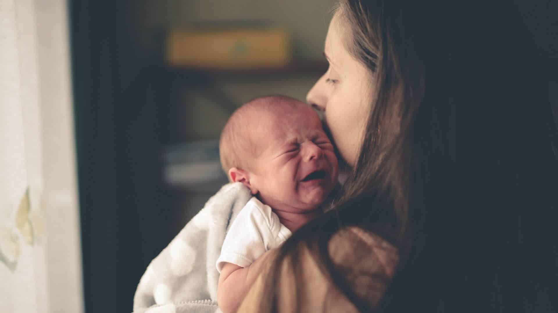 Stock image of baby Woman holding crying baby