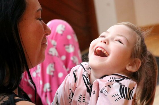 Young girl in pink top laughing / smiling