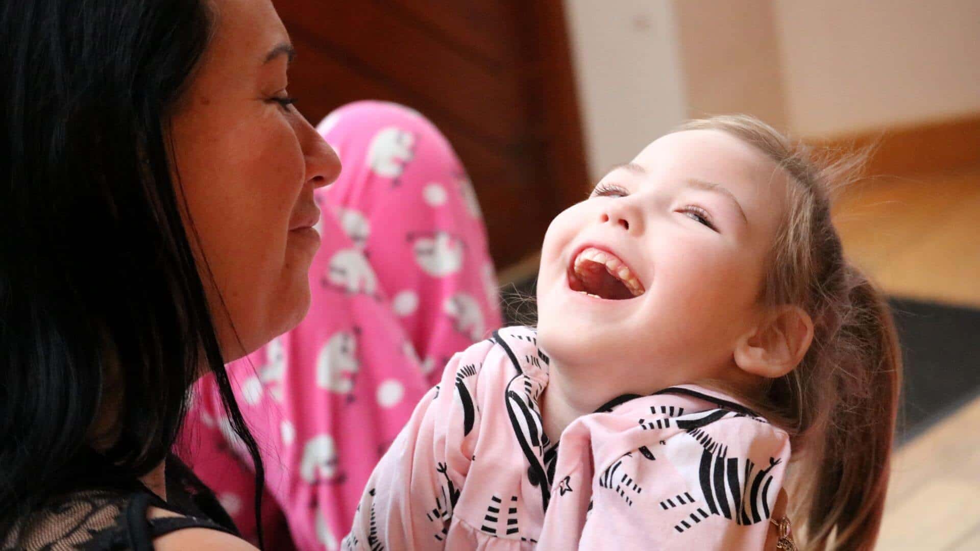 Young girl in pink top laughing / smiling