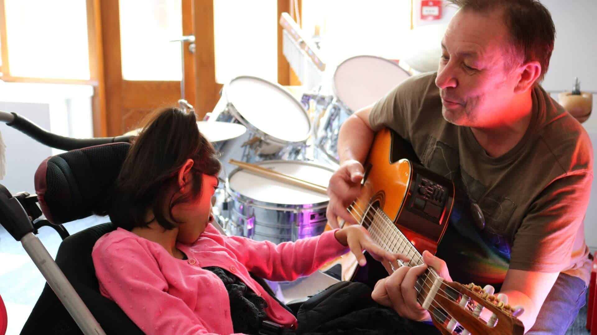 Man playing guitar with young girl