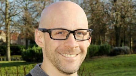 Close up of Ross Smith wearing glasses and smiling in Martin House Gardens