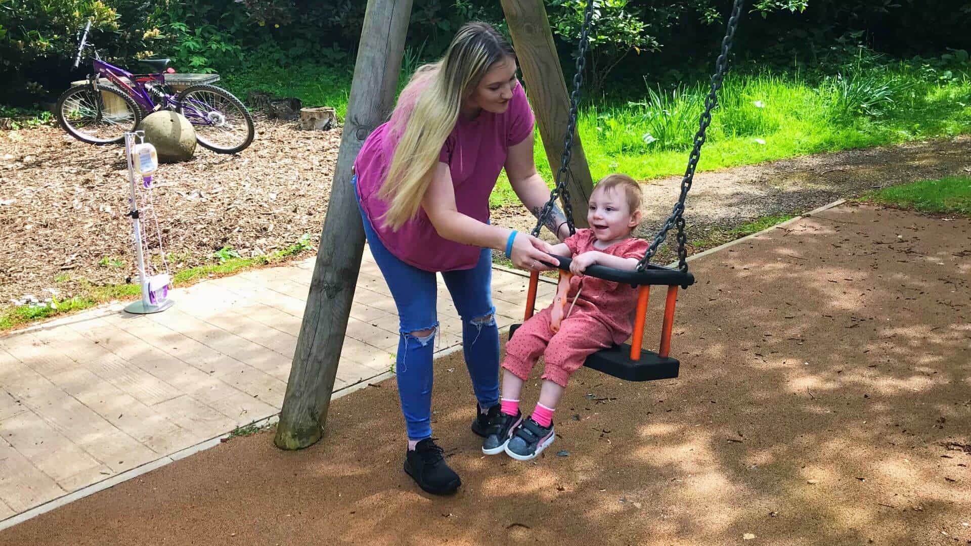 Mum Courtney and Minnie playing on swing in Martin House.