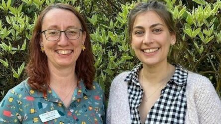 Photo of Mandy and Annie in front of greenery.