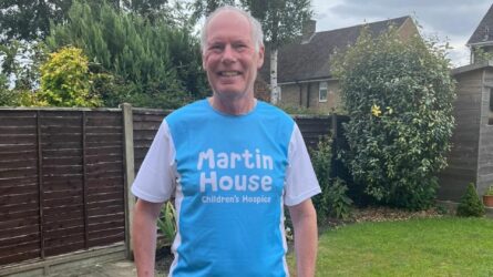 Man wearing blue Martin House t-shirt standing in his garden.