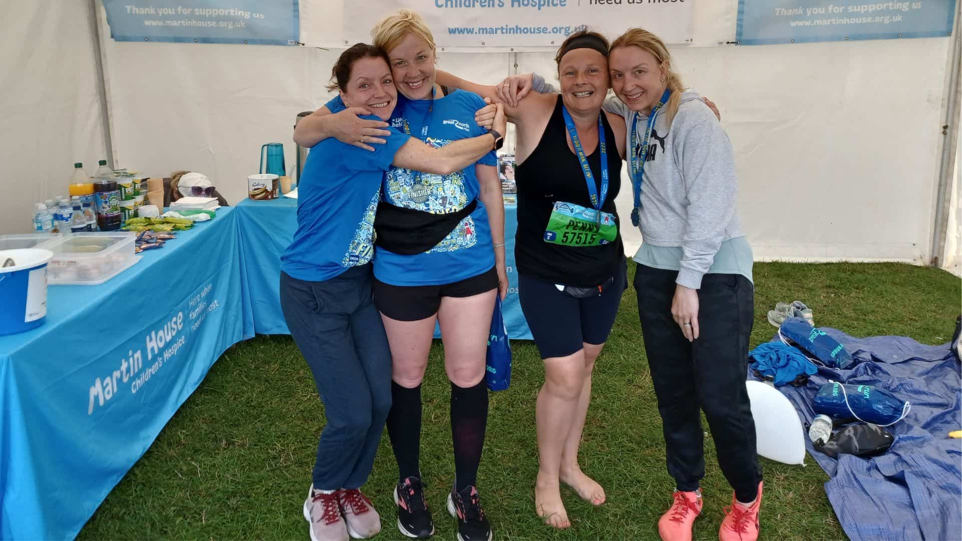 Four women smiling after completing run.