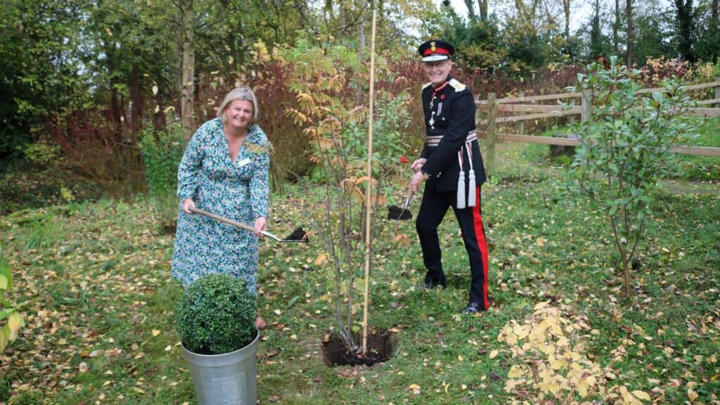 Chief Executive Claire Holdsworth and Mr Anderson planting Queen's tree in hospice gardens