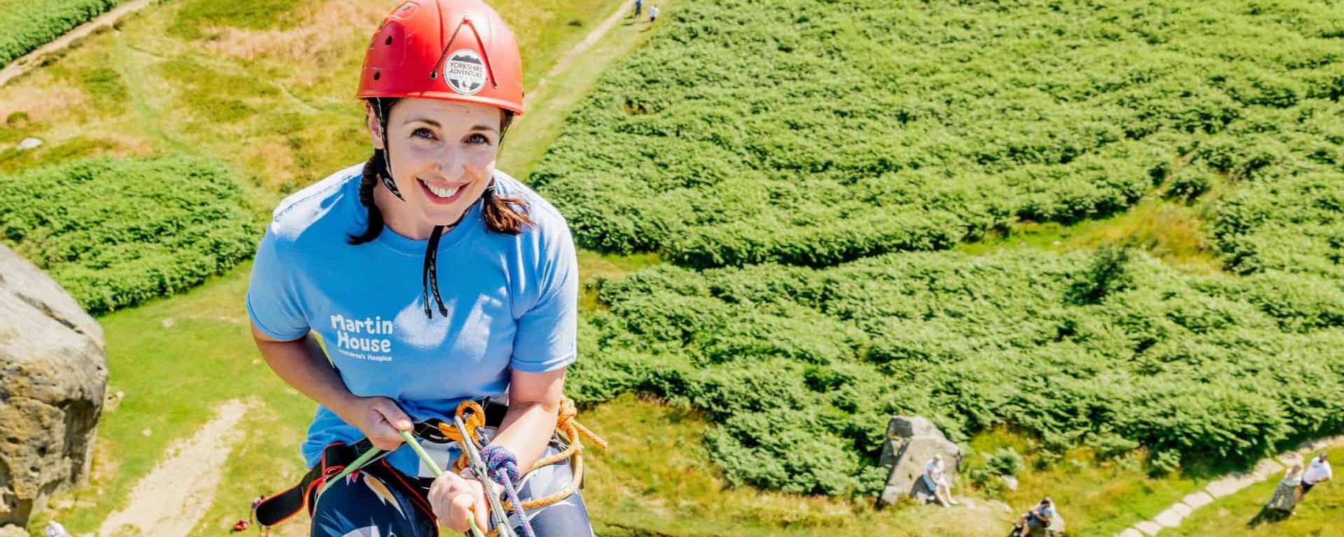 Women smiling while abseiling down cow and calf.