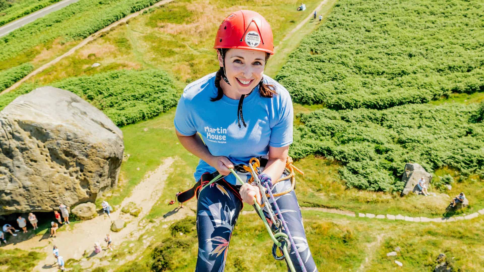 Women smiling while abseiling down cow and calf.