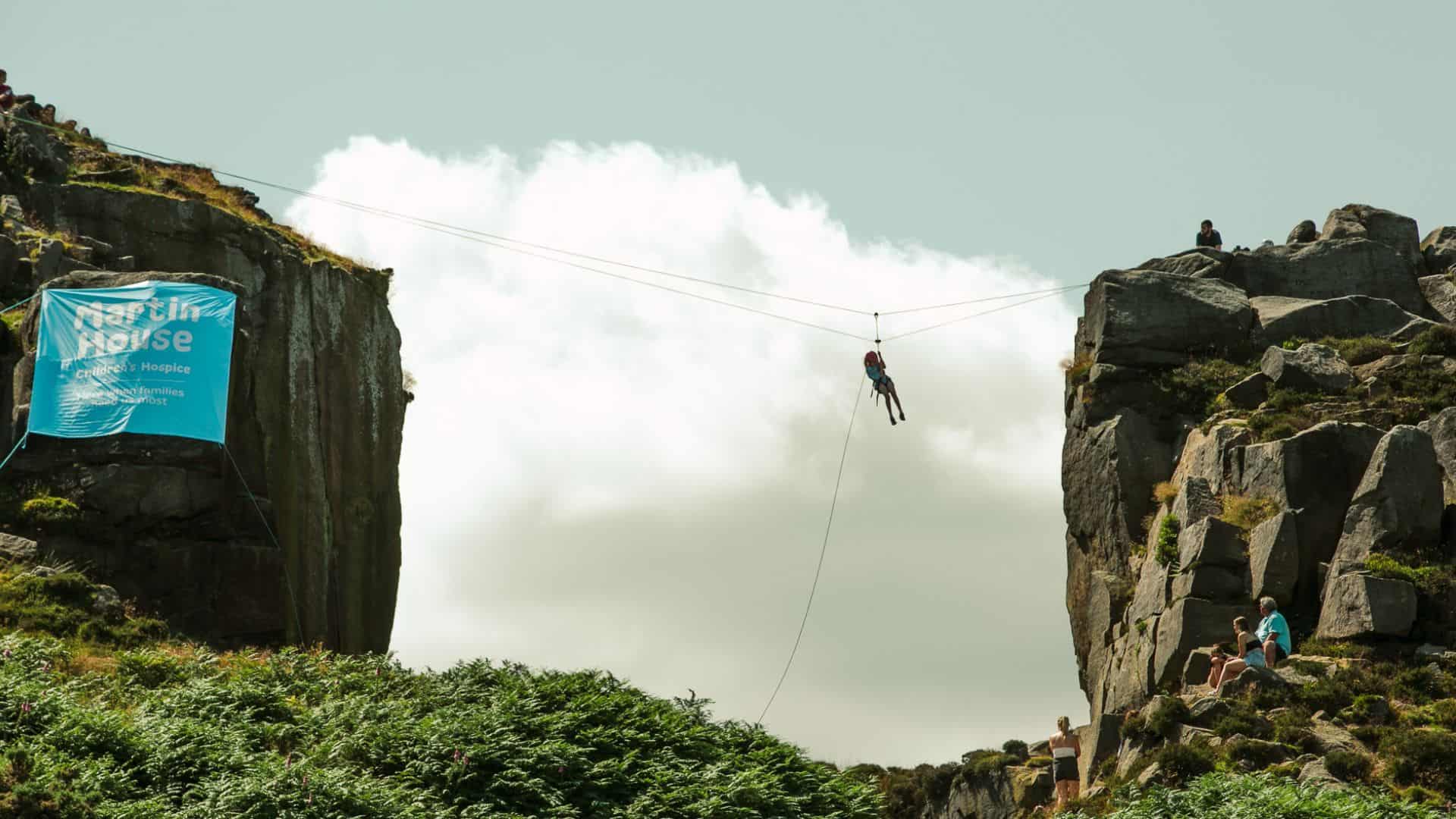 Women abseiling between the Ilkley Moor boulders.