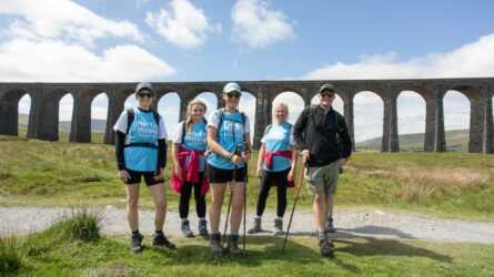 Yorkshire Three Peaks walkers smiling under viaduct.