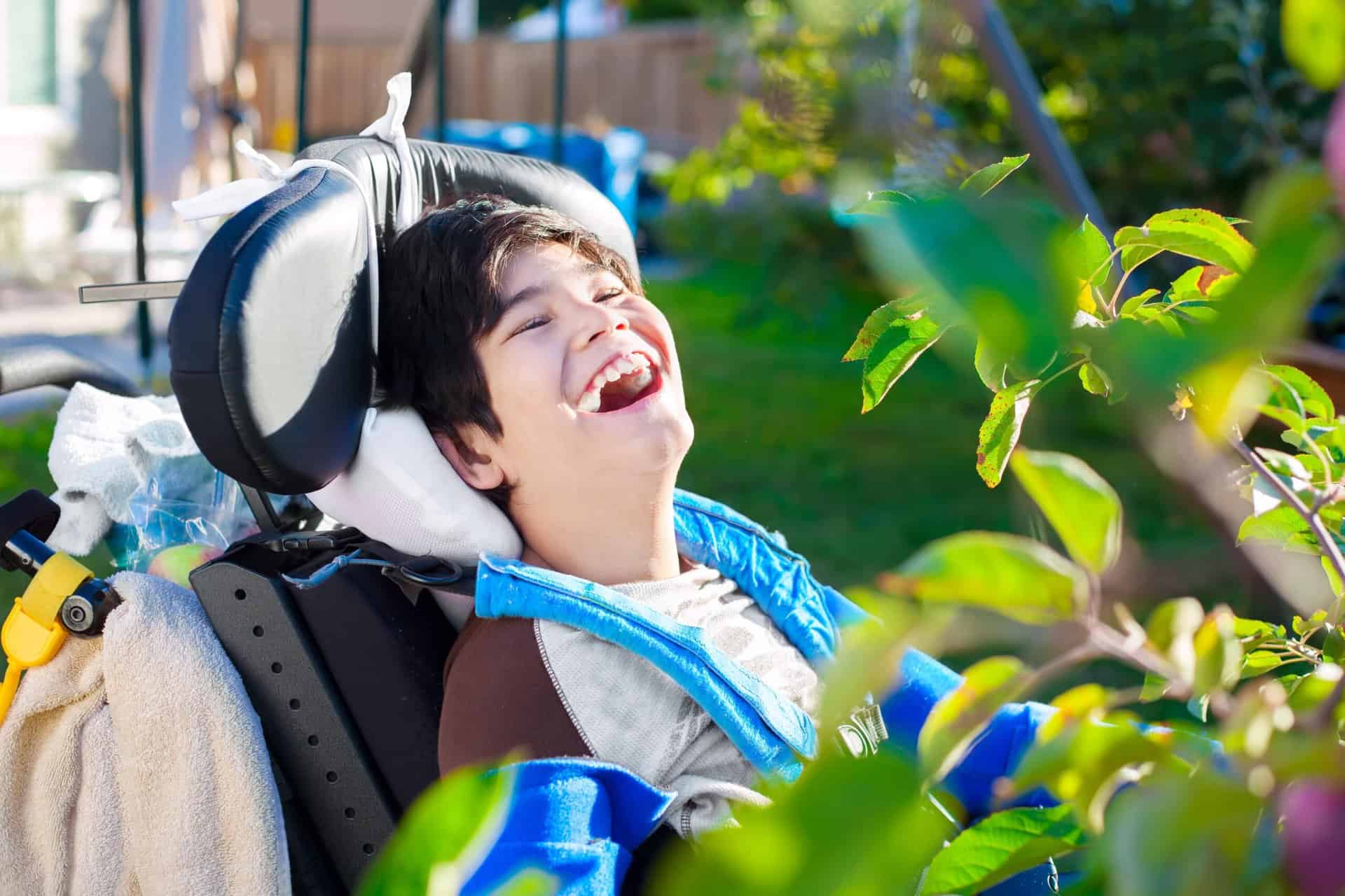 Boy in wheelchair smiling.