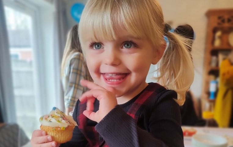 Young girl eating cupcake