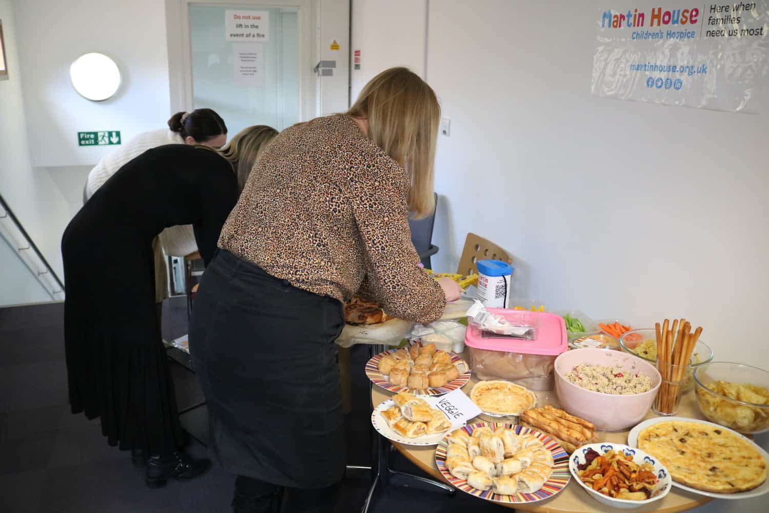 People serving themselves food at a buffet