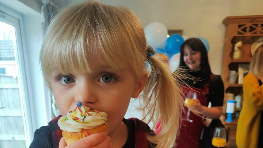 Young girl eating a cupcake.
