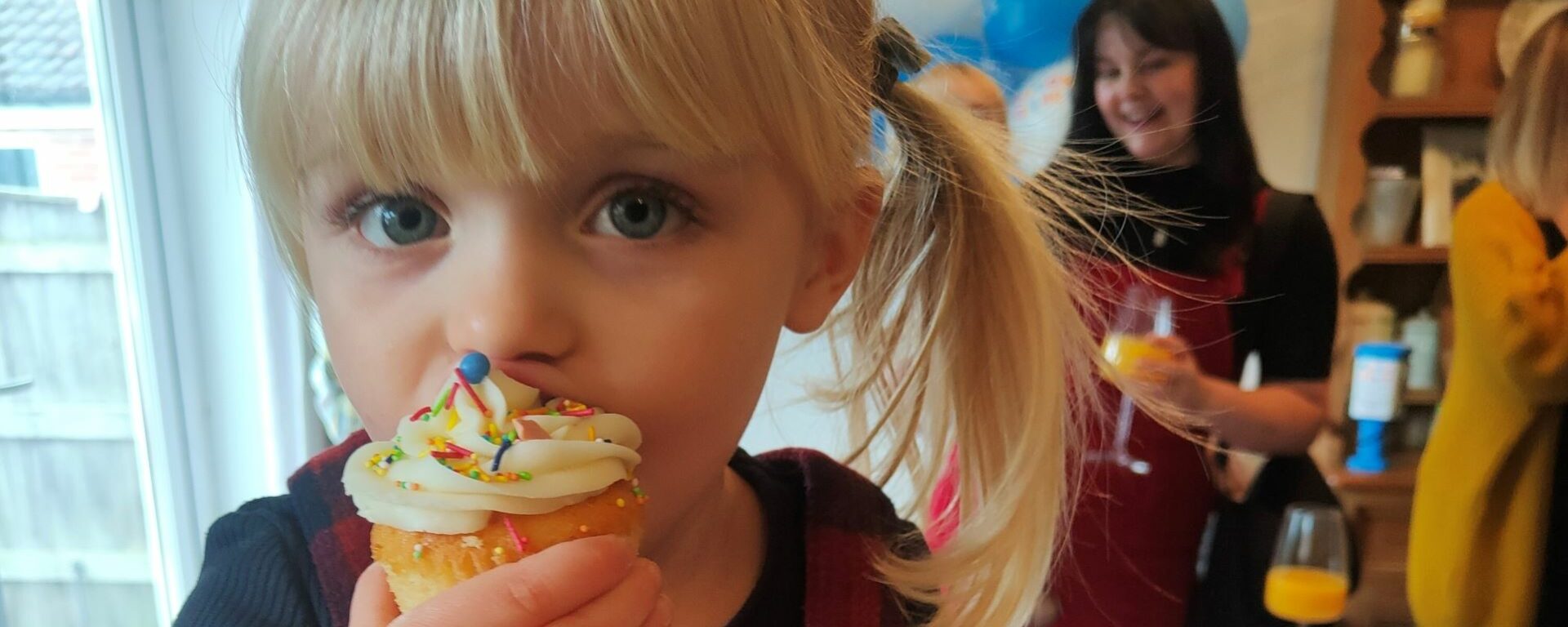Young girl eating a cupcake.