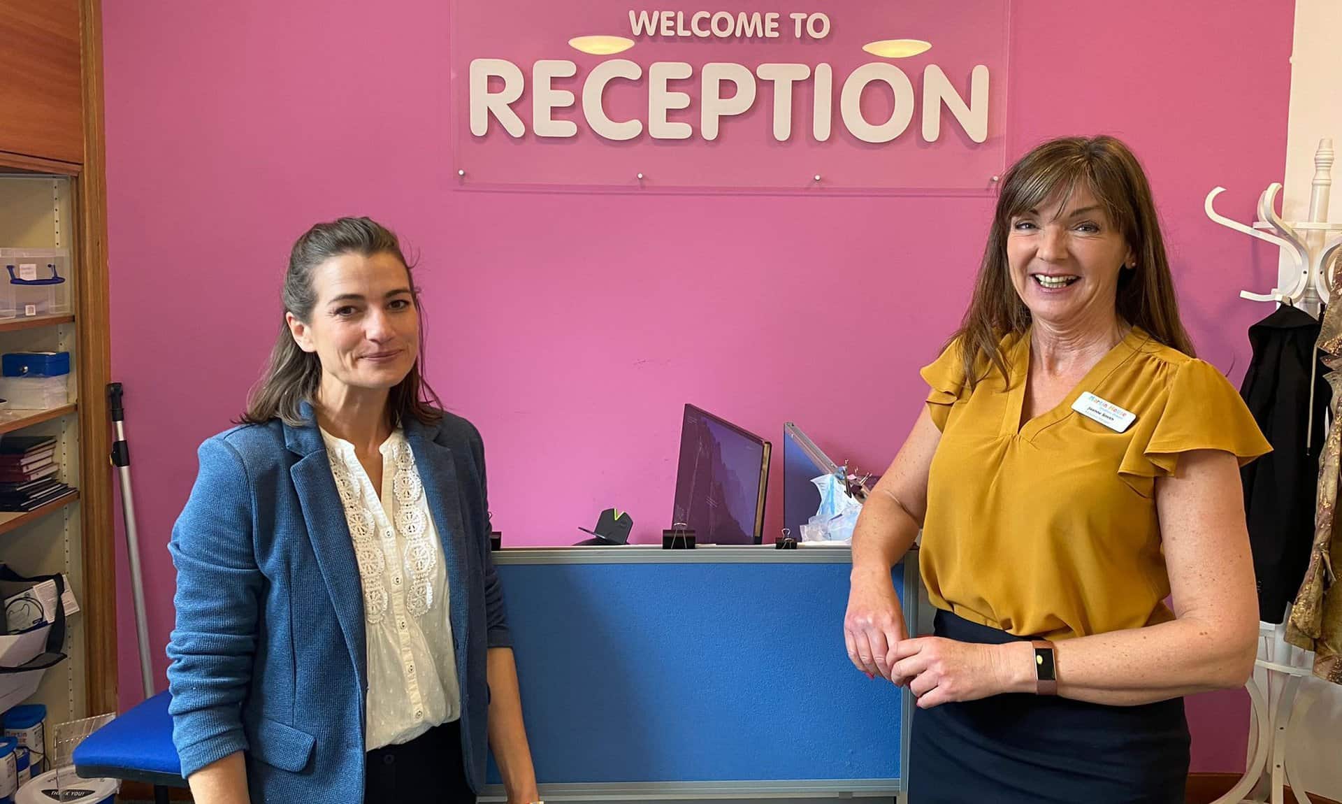 Reception volunteers with Martin House reception in background.